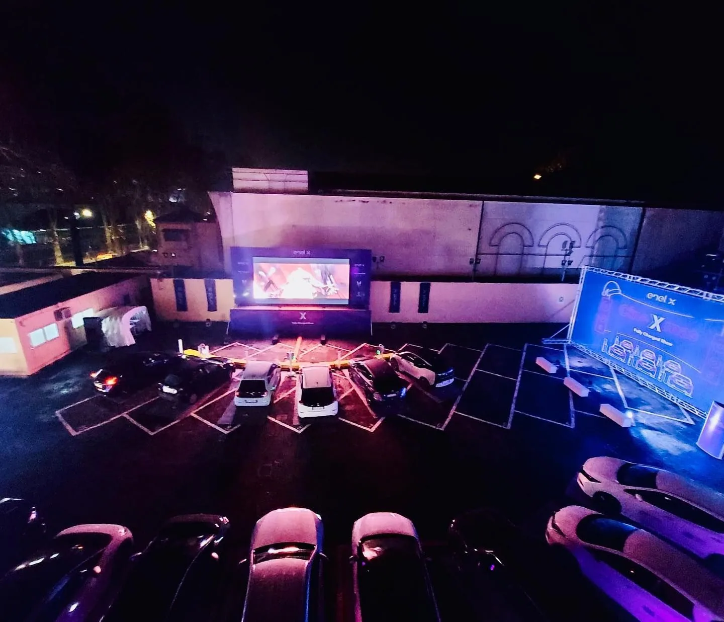 The venue seen from above: cars parked in front of the screen.