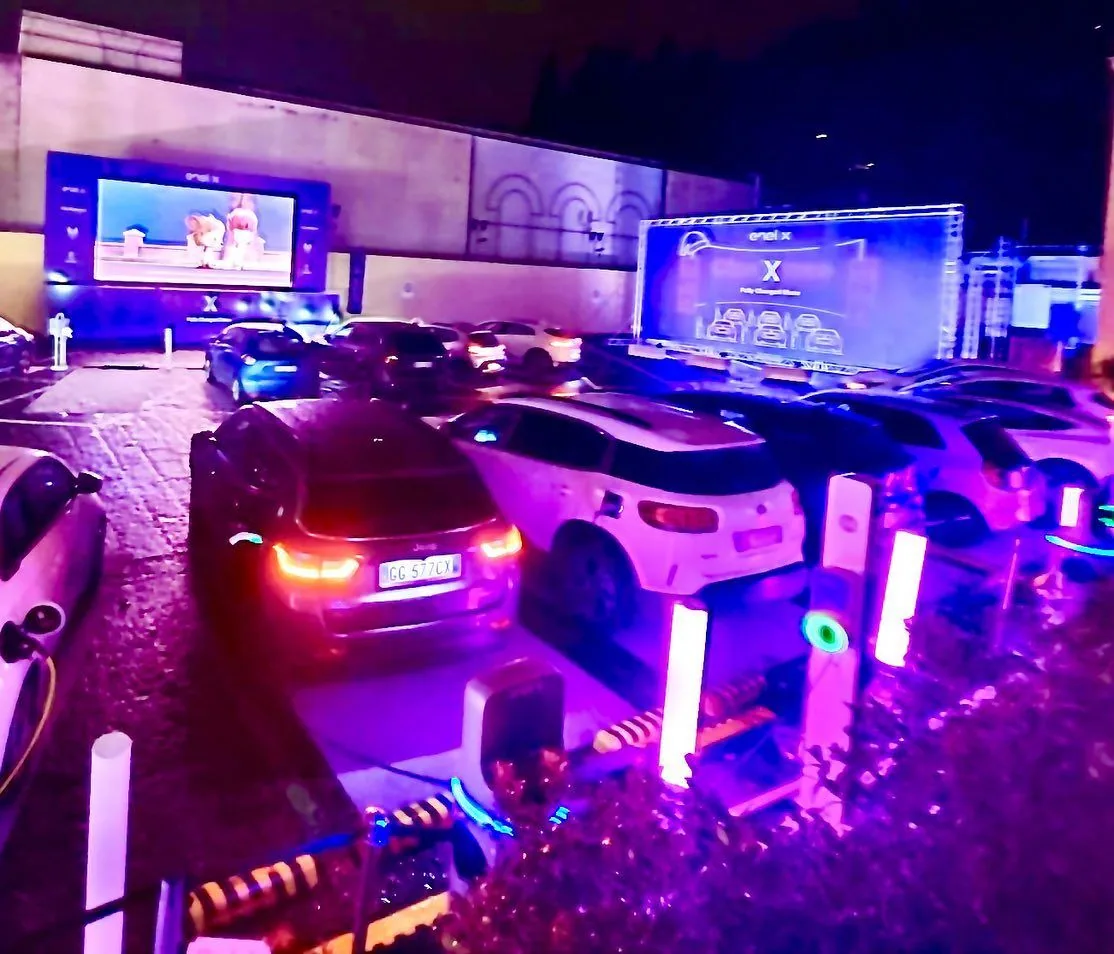 Guests' cars in place under the lighting rig before the film starts.
