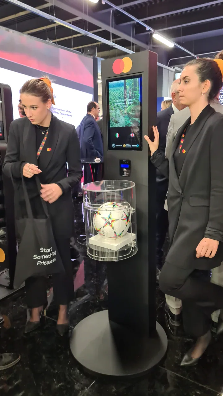 Two attendees at a totem during a Mastercard event.